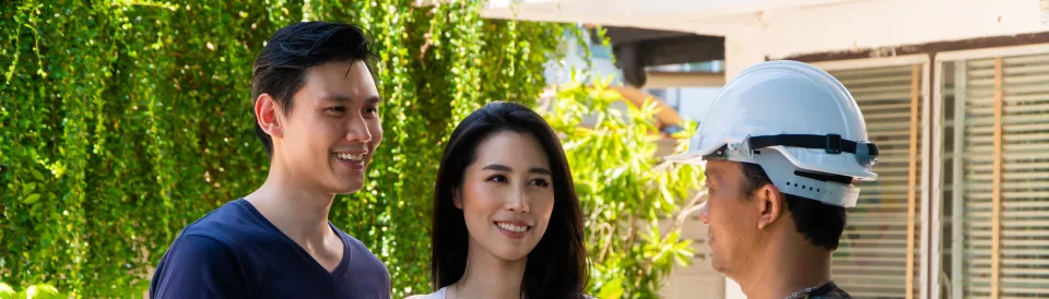 Smiling couple shaking hands with a tradesperson