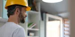 Man wearing safety hat and working on tablet