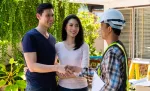 Smiling couple shaking hands with a tradesperson