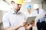 Person in safety hat looking at tablet