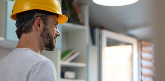 Man wearing safety hat and working on tablet